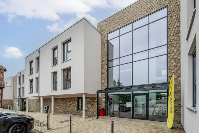 New building with bright facade, brick base and large glass front at the entrance, ipartment Wolfsburg