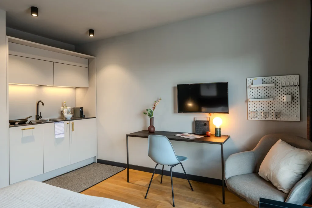 Kitchen area next to the open balcony door overlooking the half-timbered house, ipartment Wolfsburg