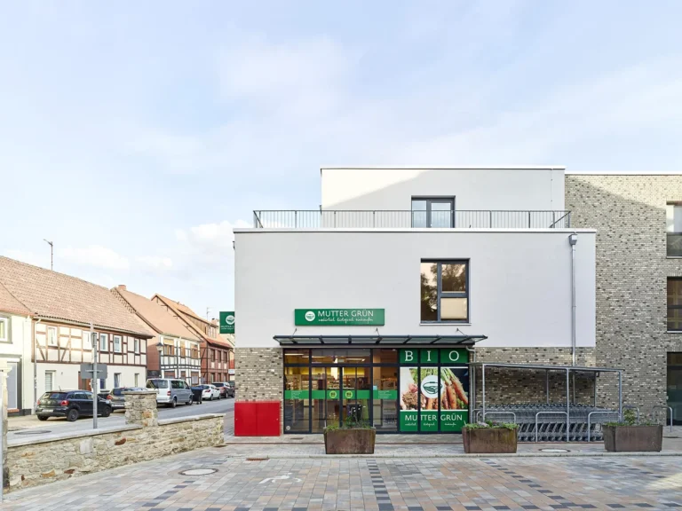 Exterior view of the Mutter Grün Bio supermarket next to historic buildings in Wolfsburg-Vorsfelde