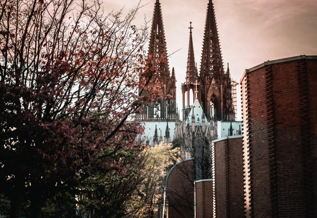 Cologne Cathedral next to a brick building in the city center of Cologne