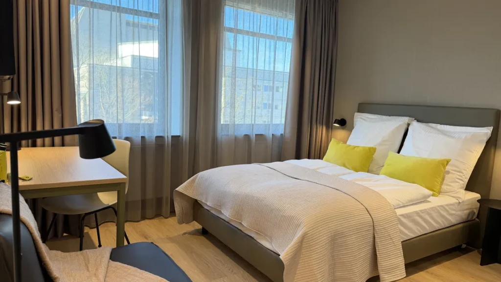 Apartment XS in the ipartment Cologne-Oper with a bed and kitchenette